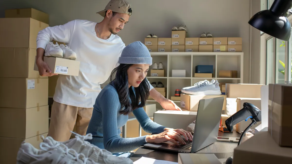 Asian woman and man online seller prepare parcel box and check orders of product for deliver to customer