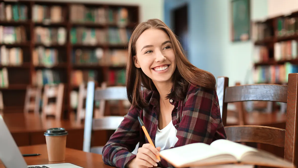 Girl studying and smiling in a library