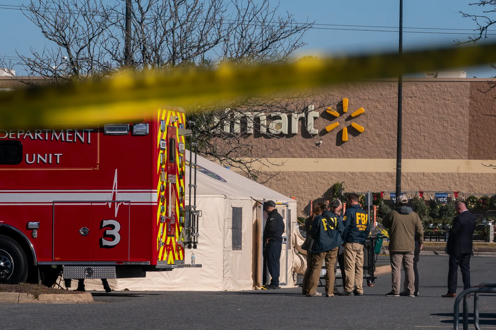 Members of the FBI and other law enforcement stand outside a tent pitched near a Walmart store in Chesapeake, Virginia.