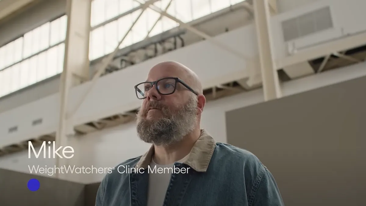 A bearded individual in a denim jacket gives testimony for Weight Watchers