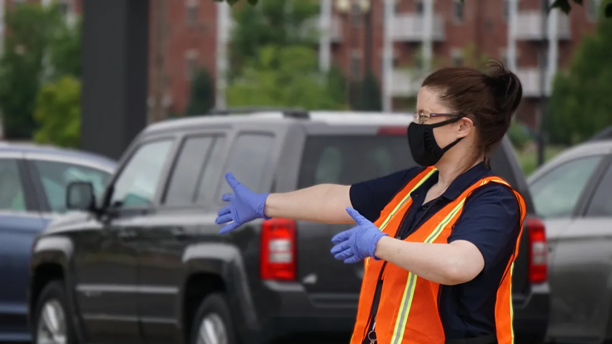 A woman directing traffic at a Wisconsin drive through job fair