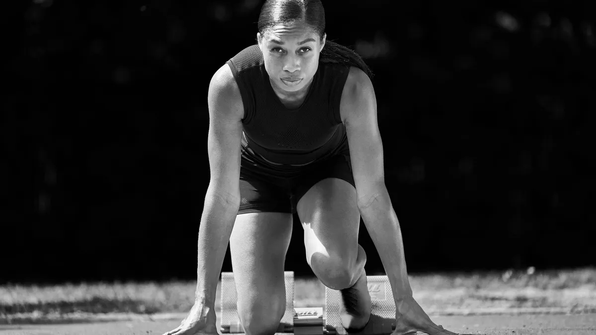 Allyson Felix crouches down in a running position.