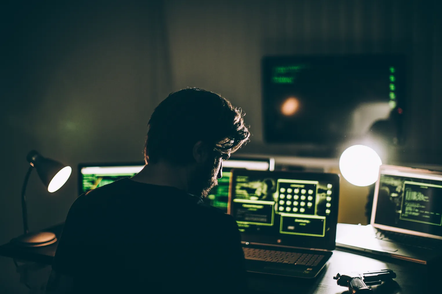 A man faces multiple computer screens.