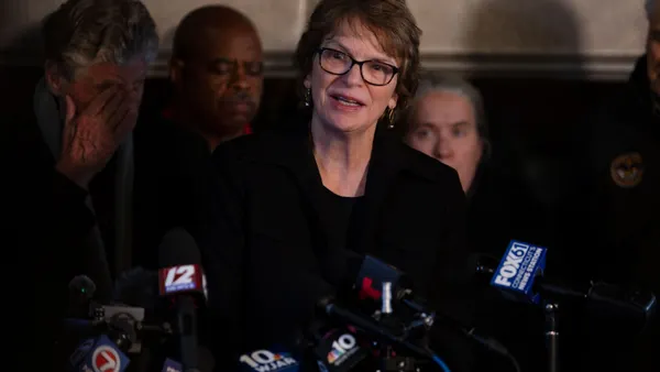Christina Paxson speaks at a podium at a press conference.