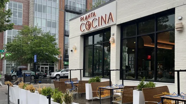 An exterior shot of a beige restaurant on a rainy day.