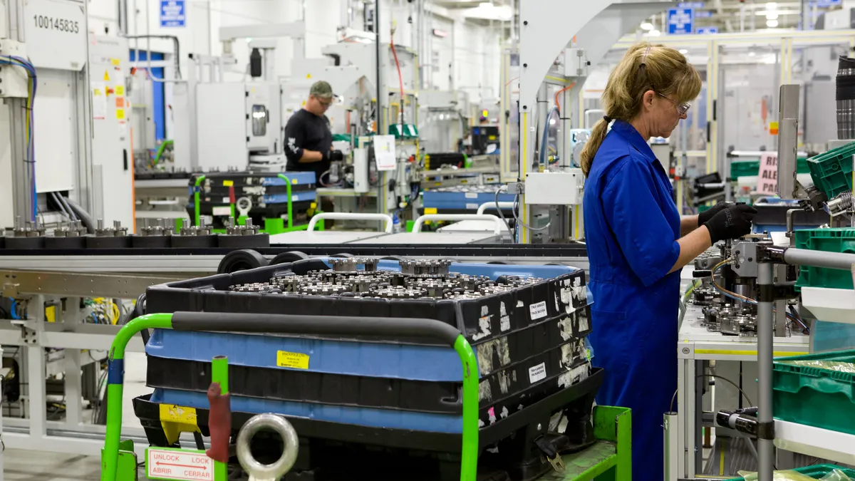 Autoworkers assemble powertrain components.