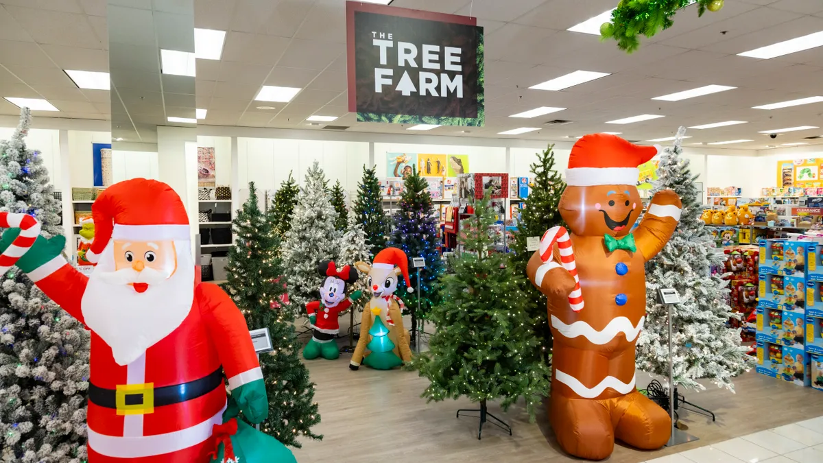 A Kohl's in-store holiday display featuring Christmas trees and inflatable characters