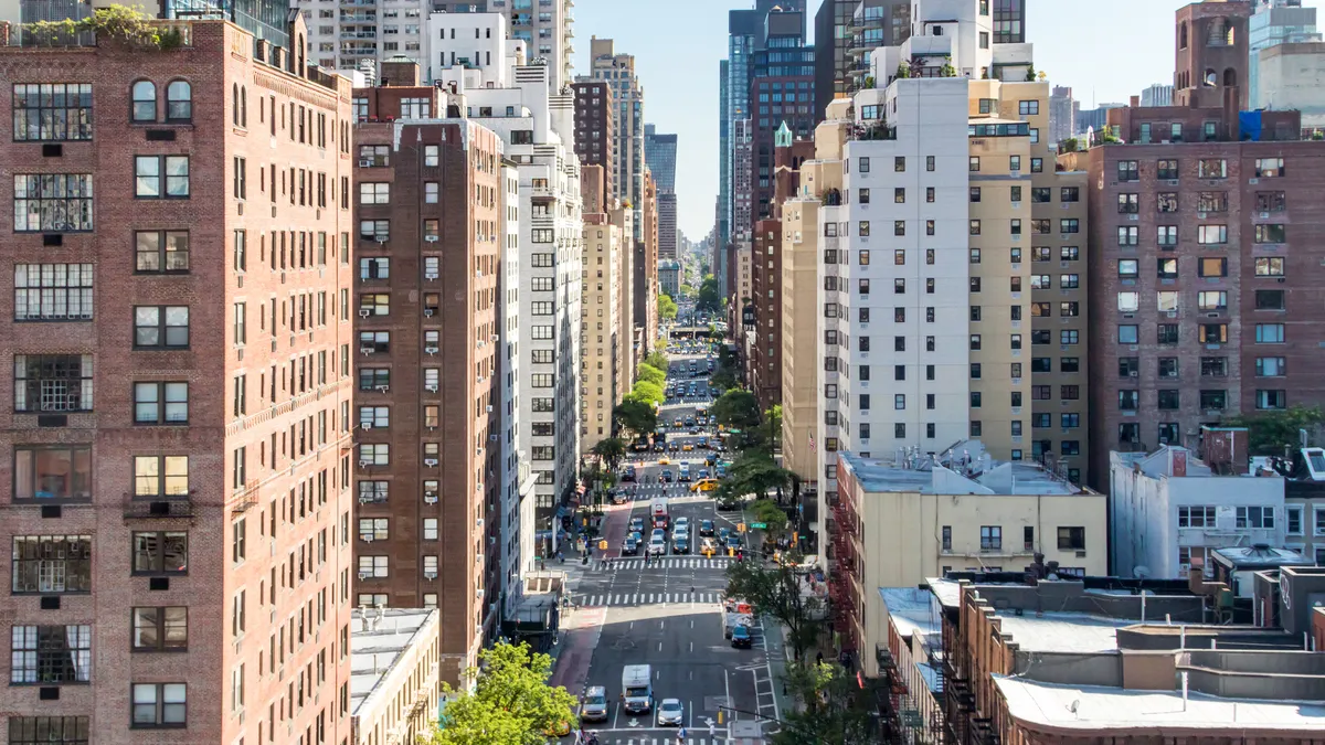 Overhead view of brick, multistory buildings along a one-way street.