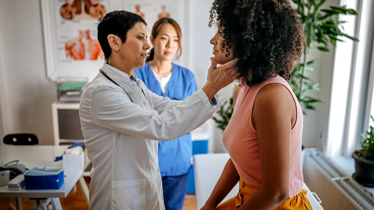 White female doctor doing a medical examination on a black female patient