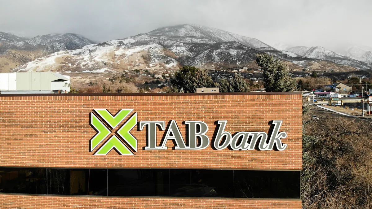 An exterior shot of TAB Bank shows the bank's name and logo on the upper corner of the building.