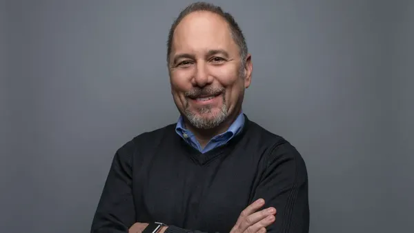 A man in a collared shirt poses for a photograph.