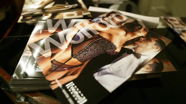 A pile of Wolford packages that feature the brand logo in gold foil and models formalwear, lingerie and hosiery.