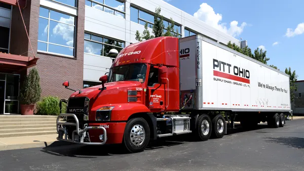 A Pitt Ohio truck sits next to a building.