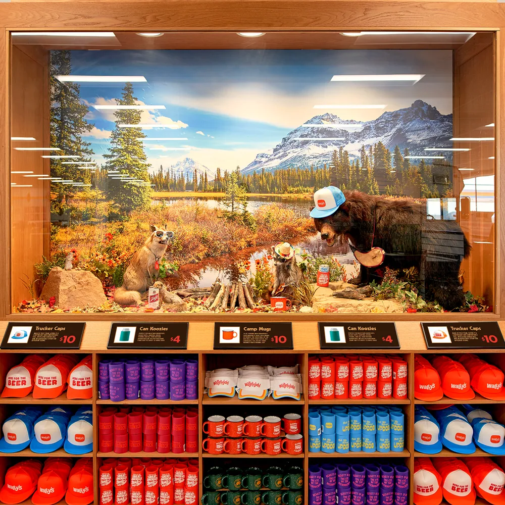 A photo of branded gear, including shirts and mugs, on shelves underneath a display of several animal statues using or wearing the items.