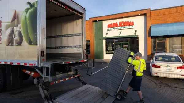 A Papa Johns worker delivers fresh dough and ingredients from a truck.