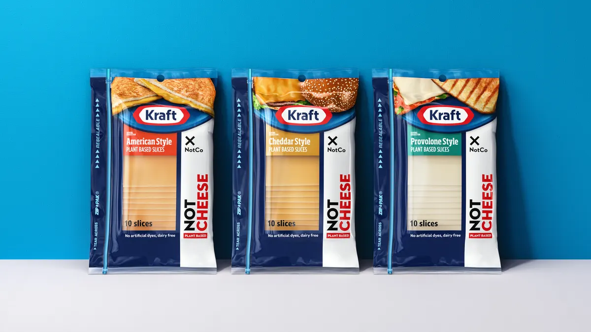 Packages of American Style, Cheddar Style and Provolone Style Kraft NotCheese slices lean up against a light blue surface with a white surface below them.