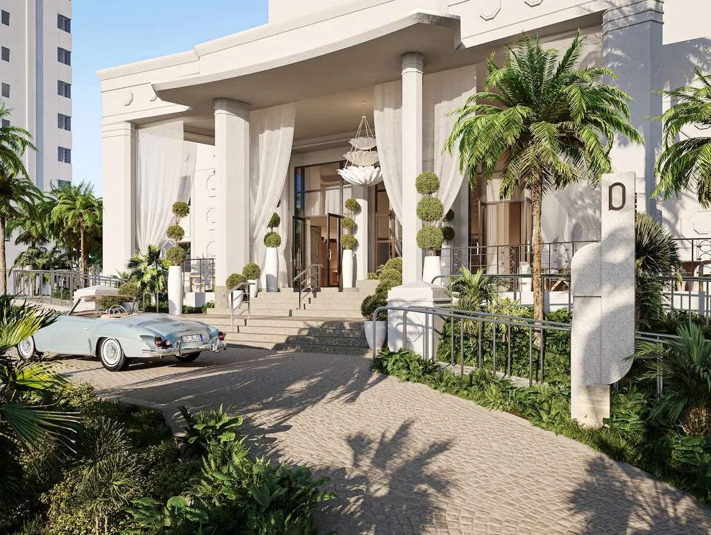 A blue vintage car sits outside a hotel entrance.