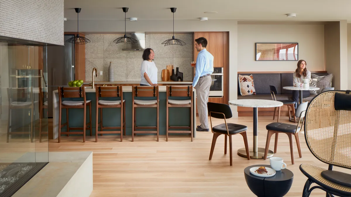 An apartment lounge with sofas and a kitchen.