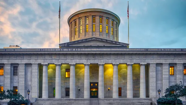 A white stone government building with columns at nighttime