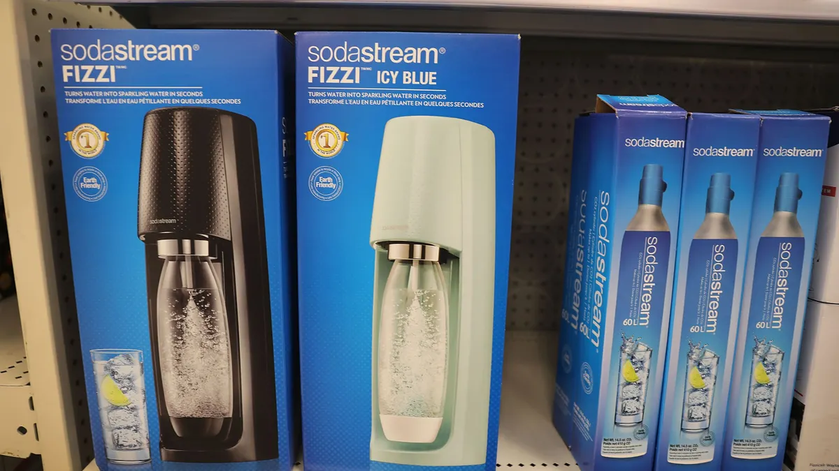 SodaStream systems in boxes sit on a retail shelf, next to boxes of SodaStream CO2 cartridge refills.