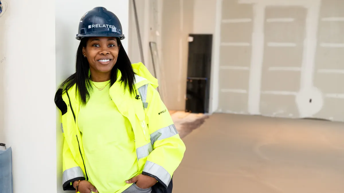 A woman wearing a construction vest and hard hat