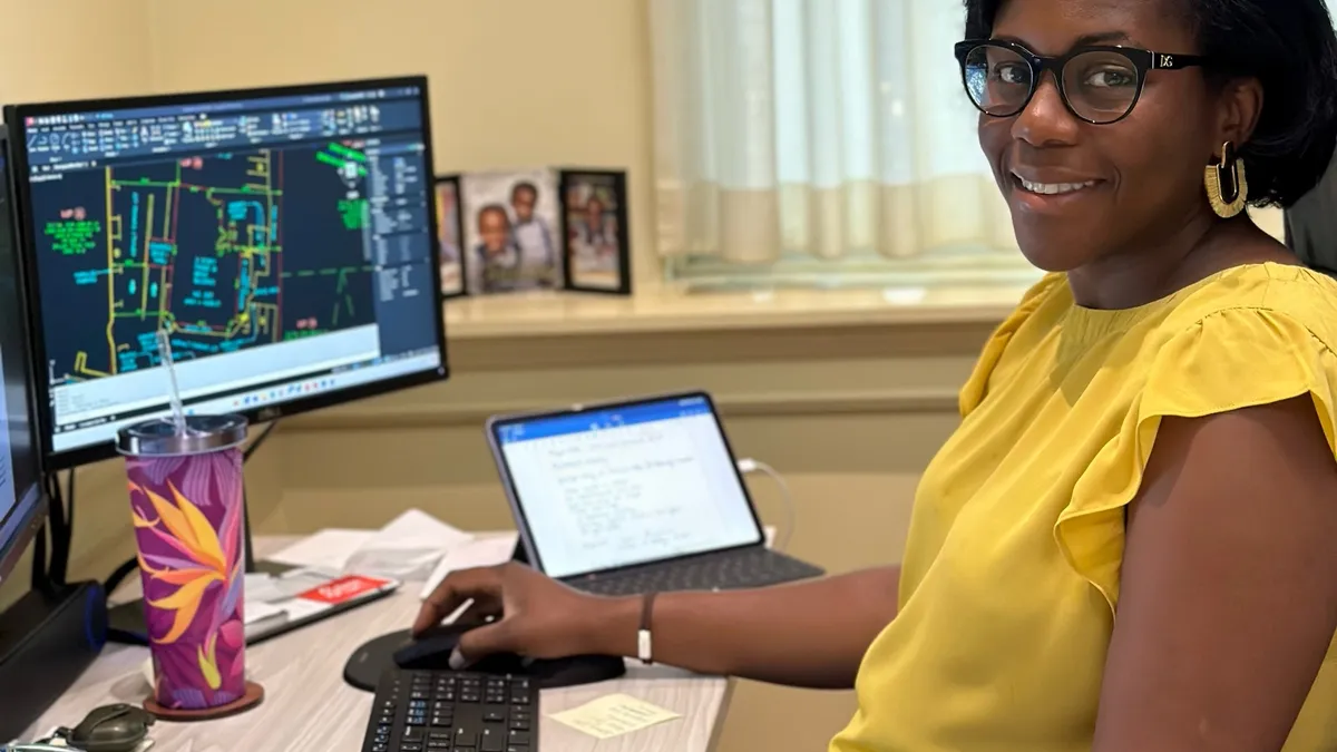 a woman works at a computer while seated at a desk