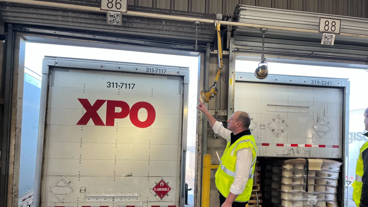 XPO CIO Jay Silberkleit points to a QR code above a door at the carrier's Hagerstown terminal in Pennsylvania.