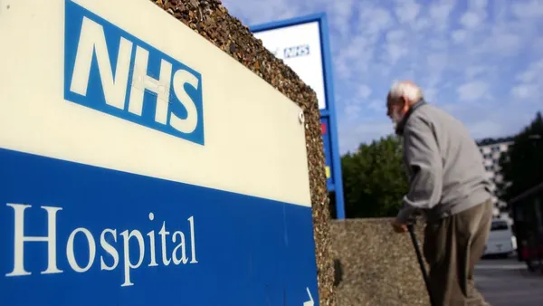 An elderly gentleman walks past a hospital sign on September 26, 2007 in London, England. In a report to be released September 27, 2007 the Healthcare Commission outlines care by the NHS Trust should provide further dignity in care to the elderly.