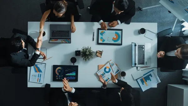 Top view of executive manager present growth graph while smart team clap hands and shale hand with marketing group to celebrate successful project.