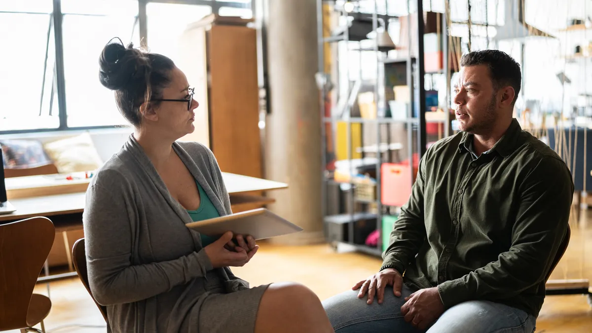 A trans man sits with his manager and has a one-on-one meeting