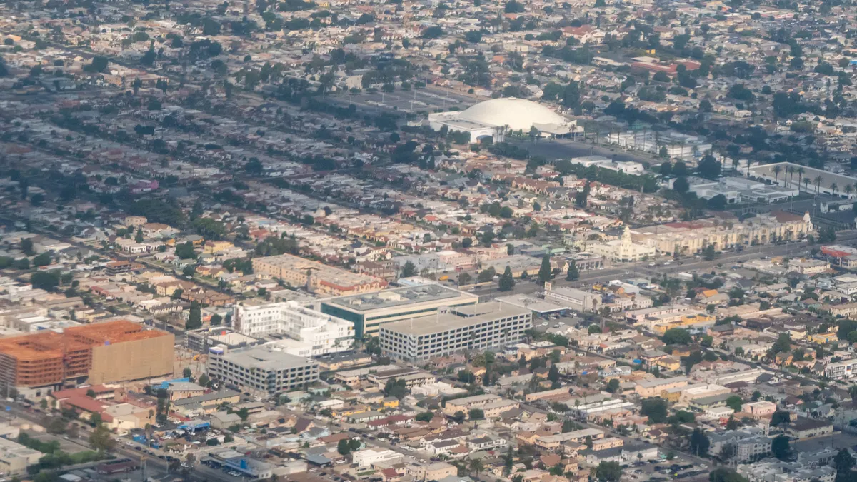 A sprawling urban landscape featuring densely packed residential and commercial buildings, streets, and intersections