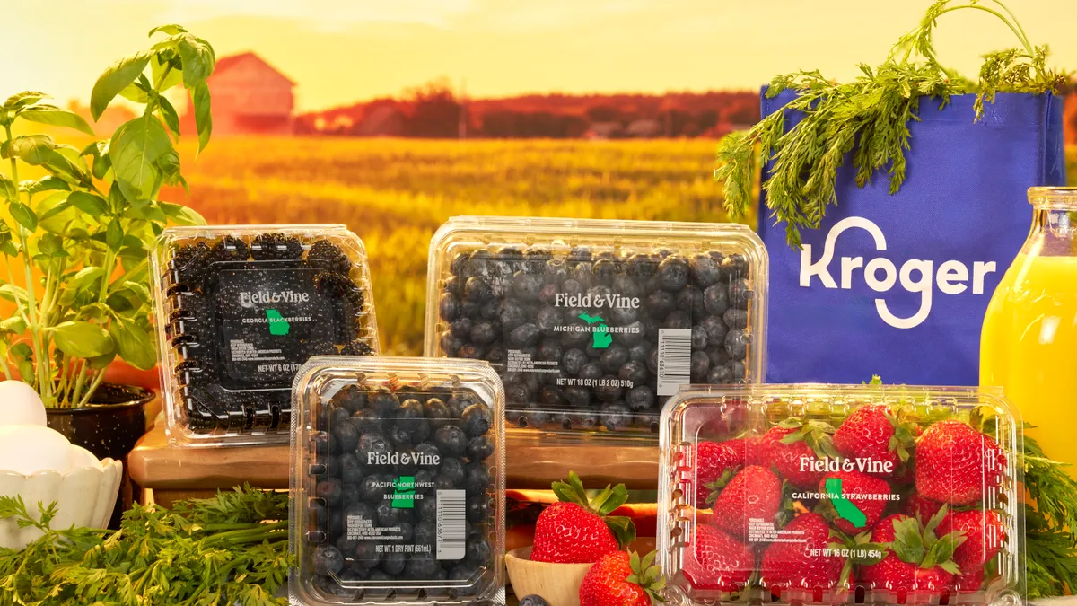 Packages of fresh blueberries, blackberries, raspberries and strawberries in front of a Kroger bag.