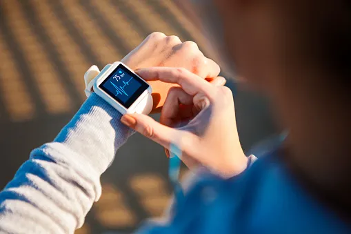 Person checks heartbeat on smart watch