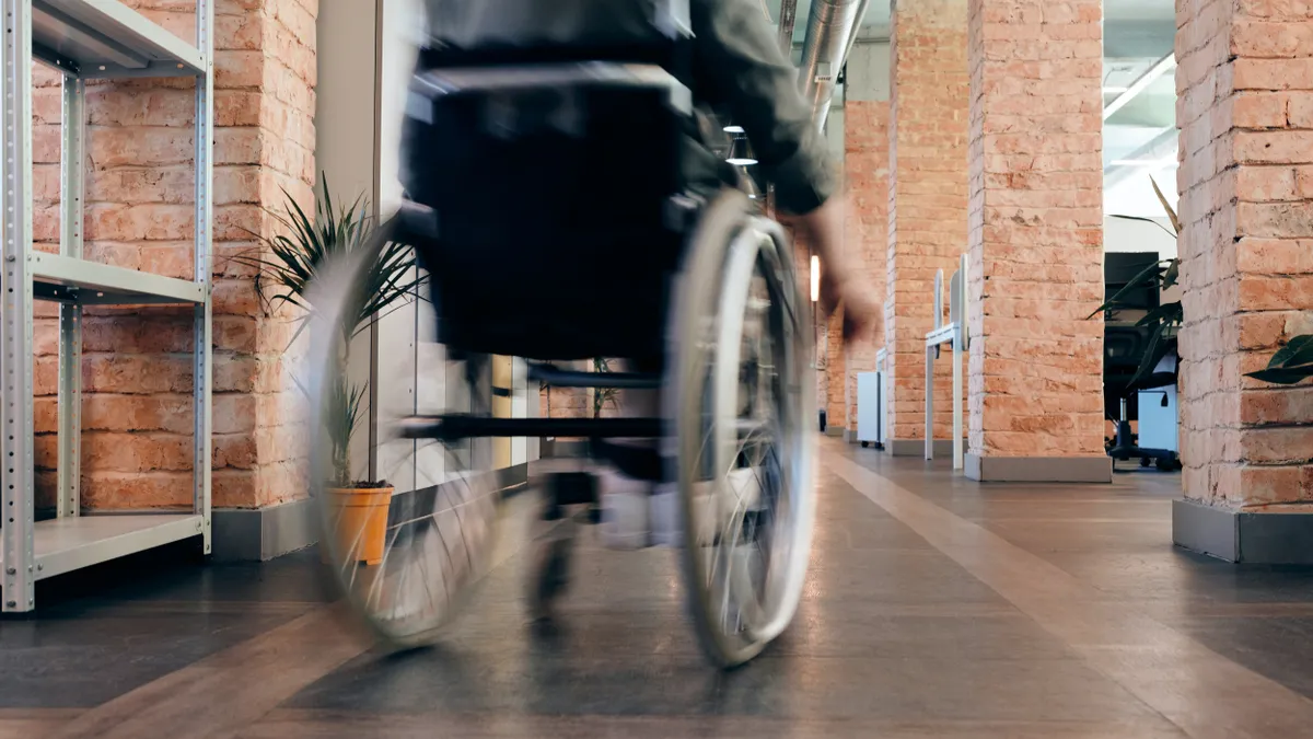 A wheelchair zooms down the hallway