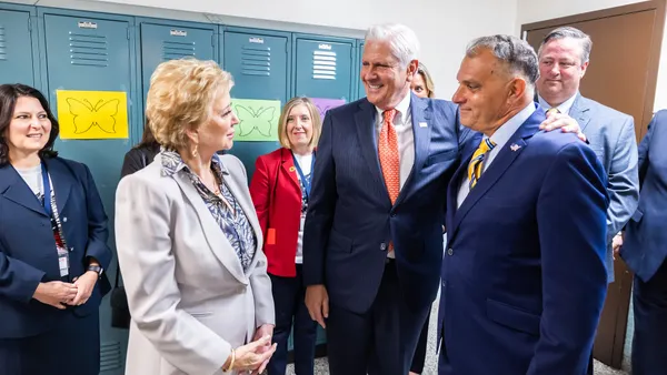 Secretary Linda McMahon stands with two school district leaders