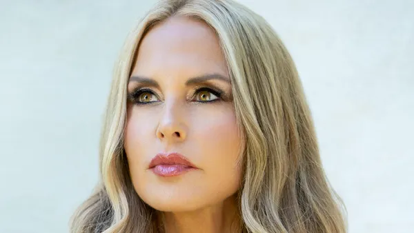 A person with long blond hair looks to the left.