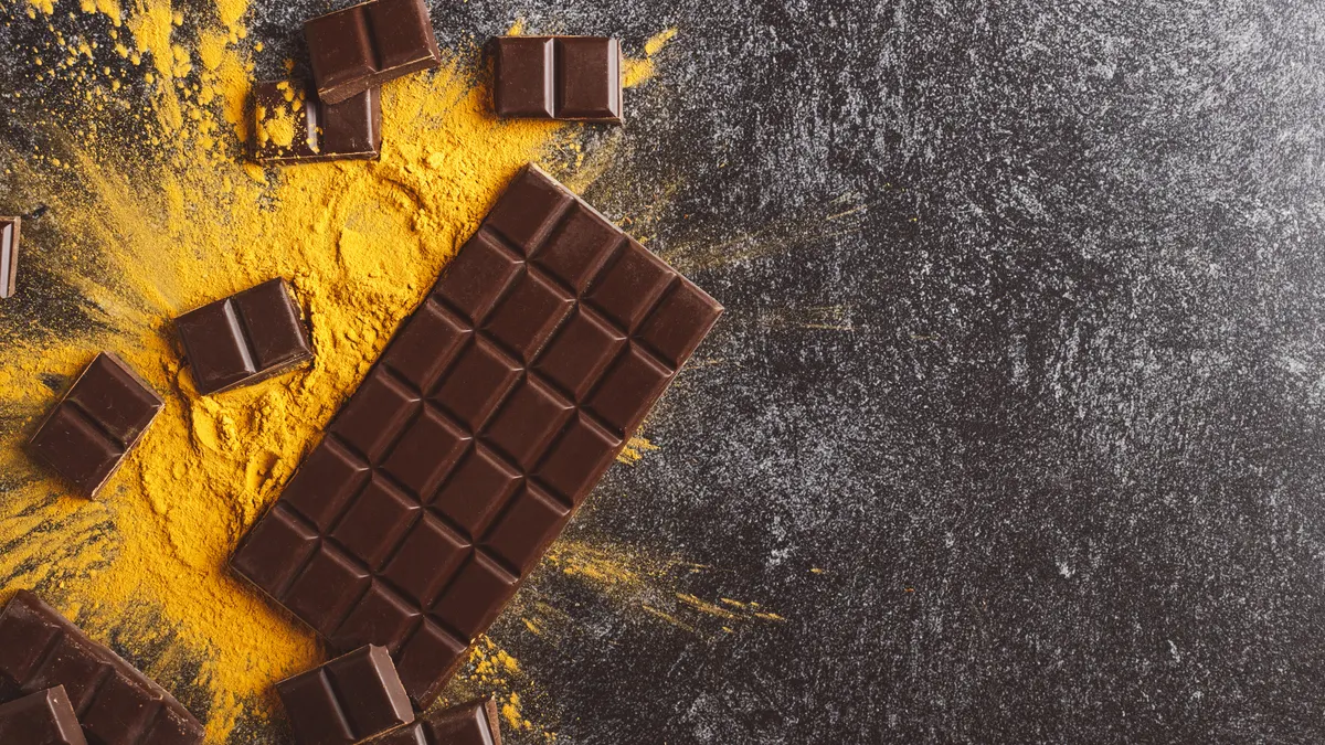 Food styling image featuring chocolate bar and powdered supplement