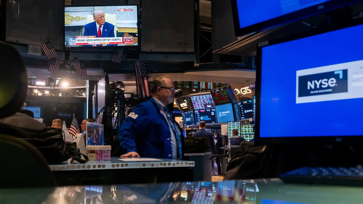 U.S. President Donald Trump is displayed on a television screen as traders work on the floor of the New York Stock Exchange.