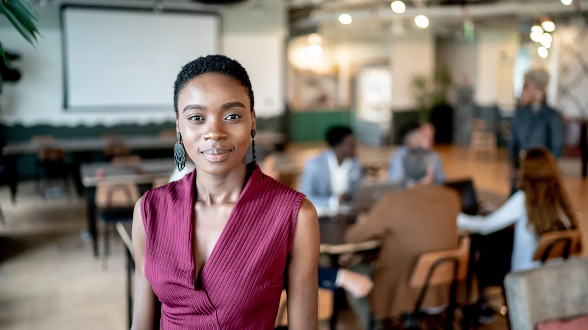 Portrait of a young businesswoman with coworkers on the background