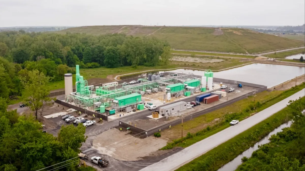 Aerial view of an industrial facility in front of a landfill.