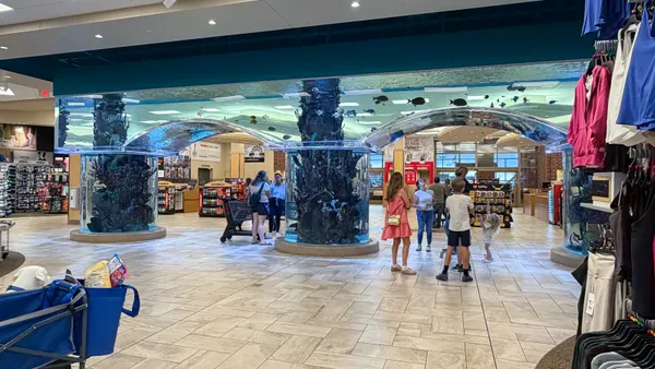 Shoppers pause at an acquarium tank inside a Scheels store in Colorado Springs, Colorado.
