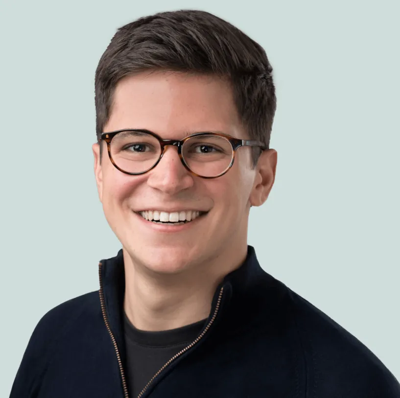 A headshot of Nico Simka, CEO of financial services company Clair. He is wearing a black sweater over a black shirt, and sporting round tortoiseshell glasses.