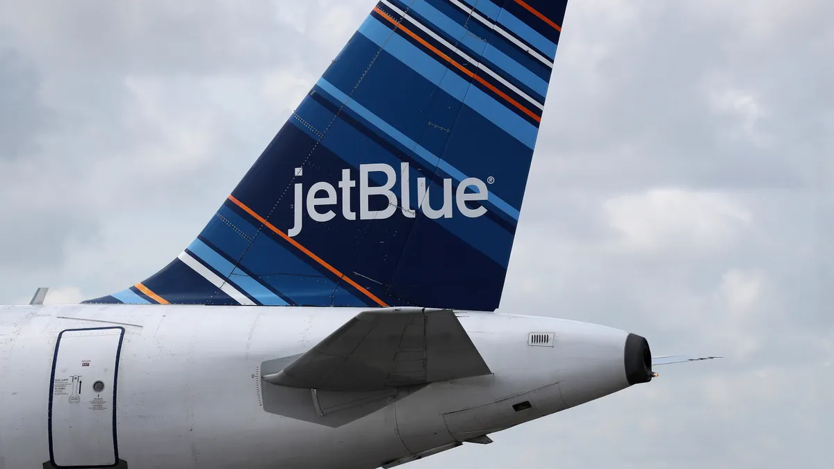 the tail and engine of a Jetblue jet airplane with the JetBlue logo