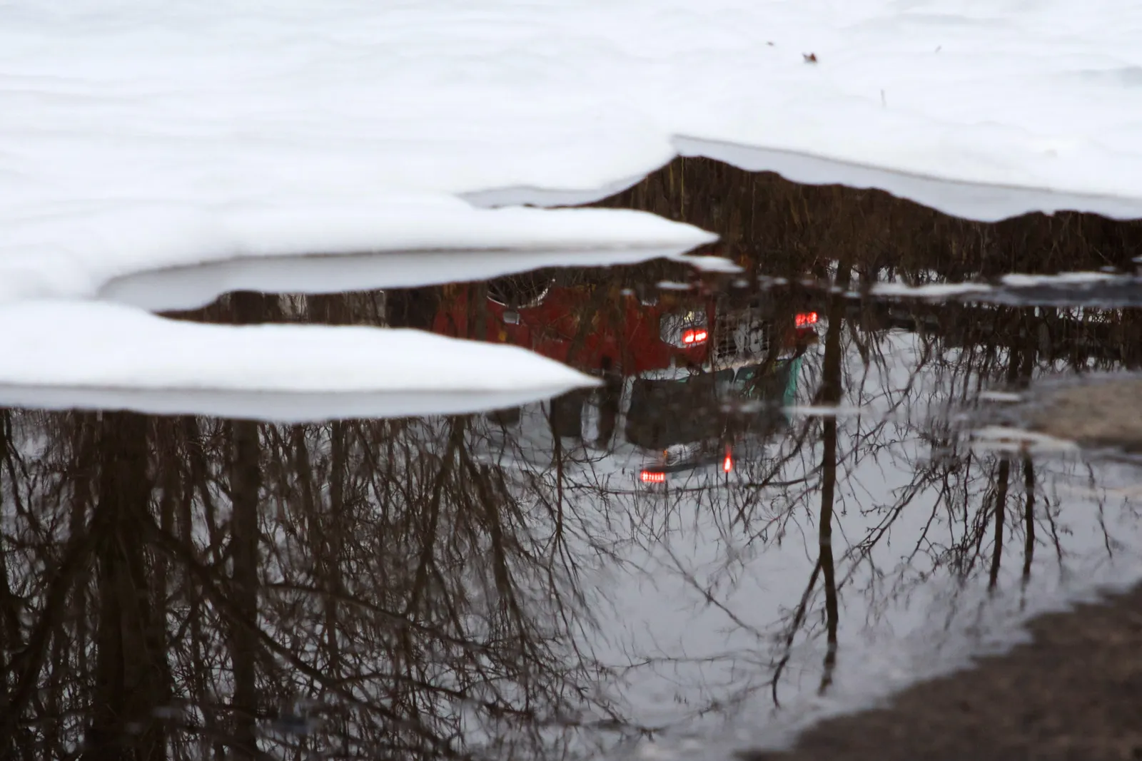 A puddle of water lying next to white foam.