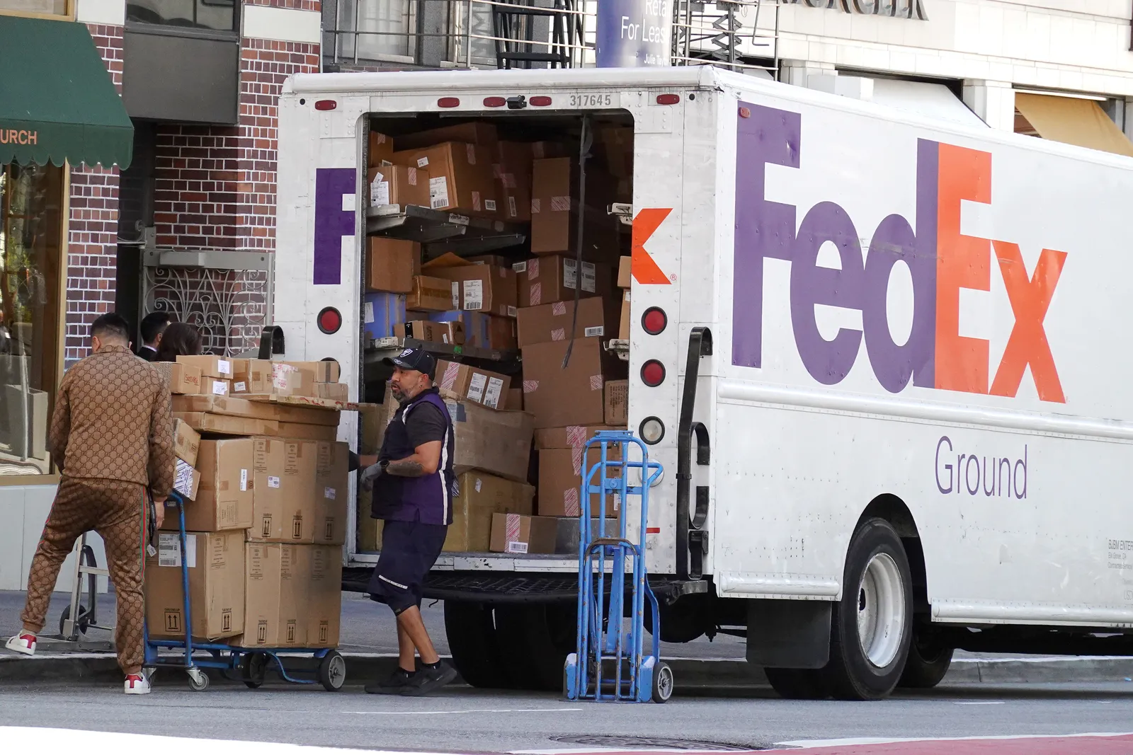 A worker loads packages into a FedEx truck on June 20, 2023 in San Francisco, California.