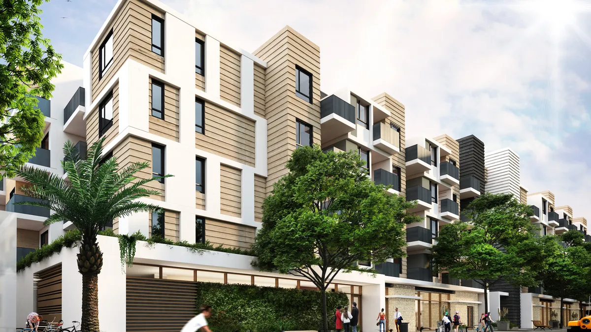 Brown and white apartment building above a garage with people on the street in the foreground.