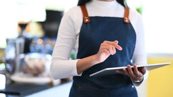 a closeup of a restaurant worker using a tablet