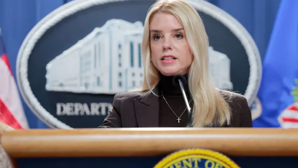 A blonde woman speaks behind a podium in the White House.