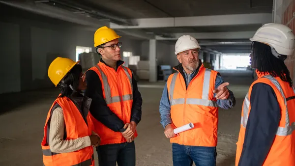 A group of people in construction gear have a meeting.