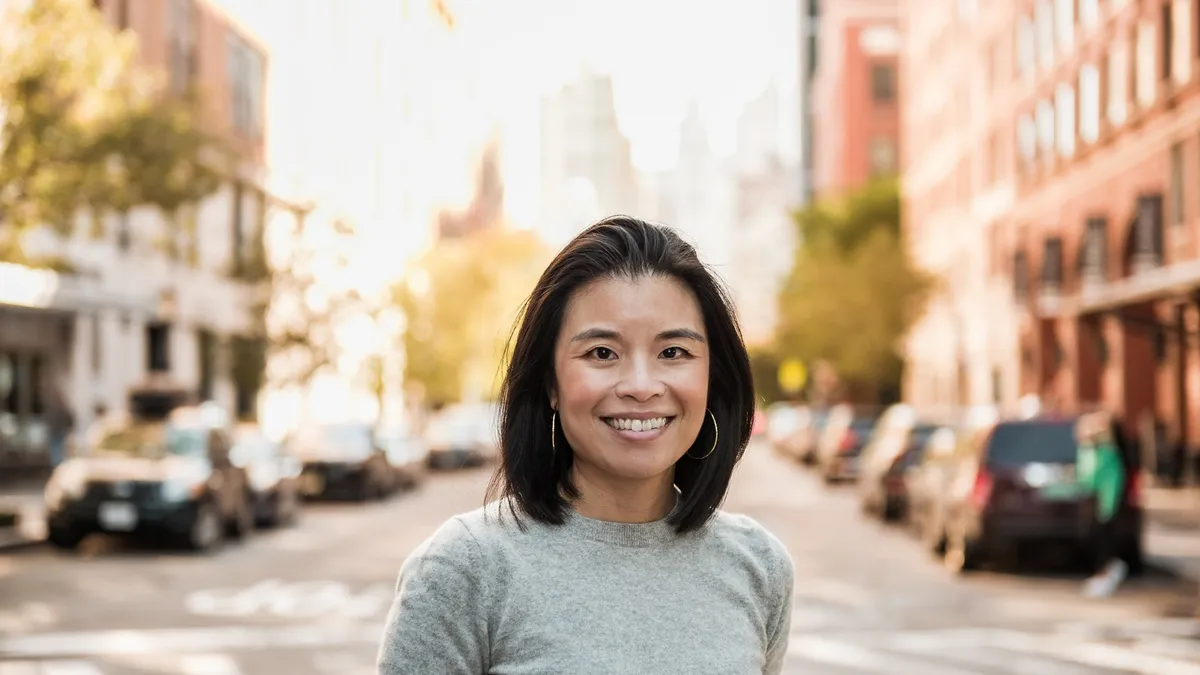 CMO Melody Lee wearing a gray shirt standing outside